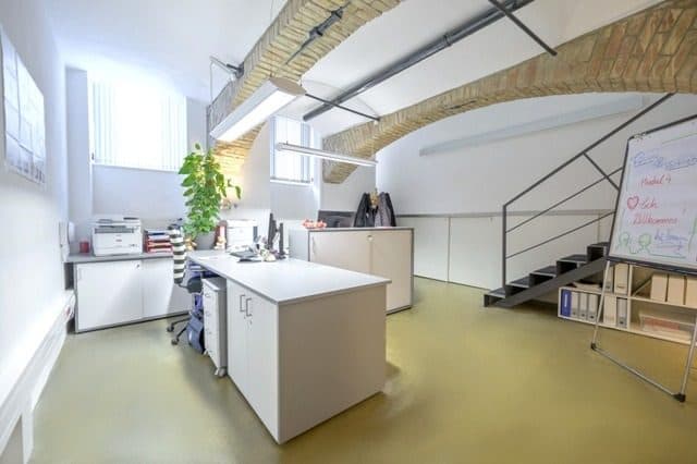 Büroraum mit Gewölbedecke, Schreibtisch und Aktenregal