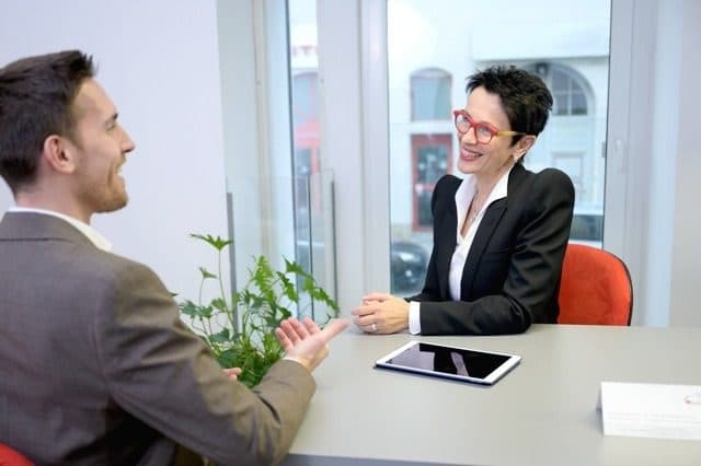 Trainerin und Teilnehmer lachen im Gespräch