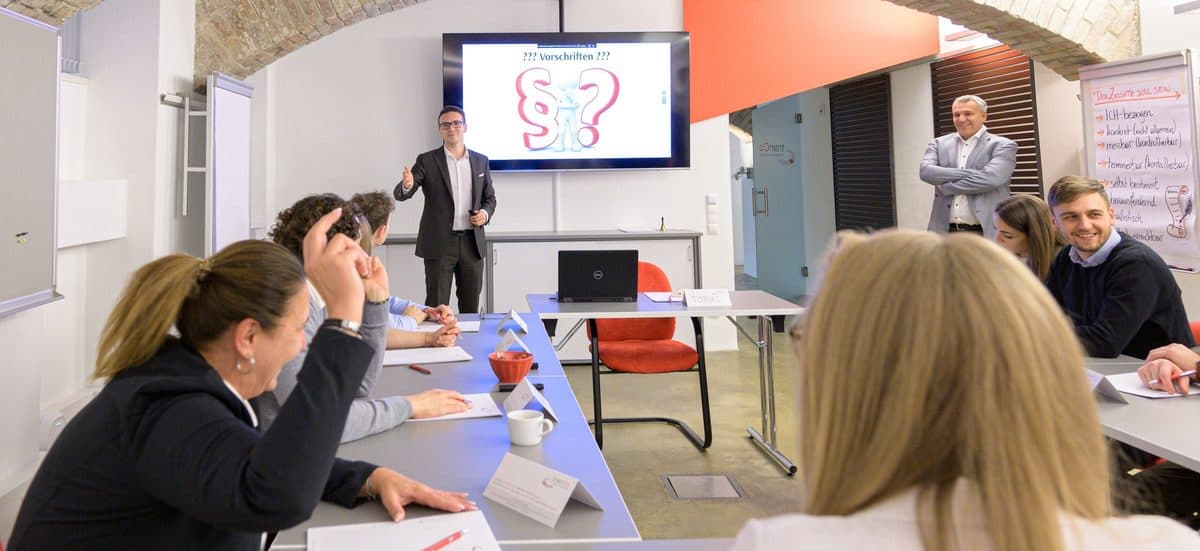 Seminargruppe von hinten, vorne die Trainerin am Bildschirm